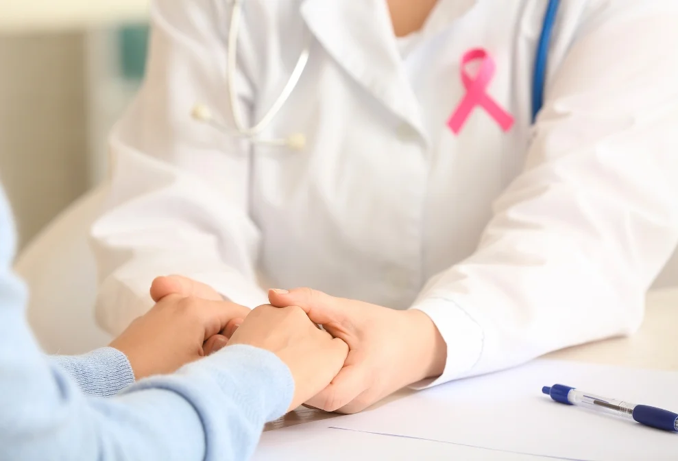 Médico oncologo sosteniendo las mano a un paciente